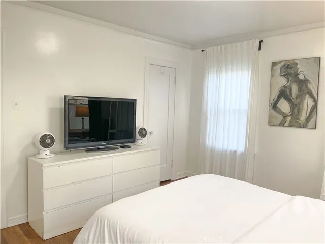 a bedroom with a bed and a flat screen tv