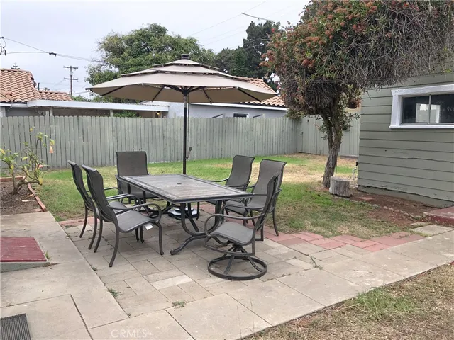 a view of a patio with furniture and table under an umbrella