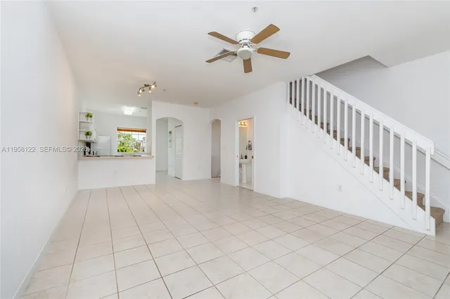 a view of a hallway with a chandelier fan and wooden floor