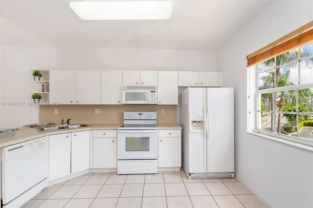 a kitchen with white cabinets and white appliances