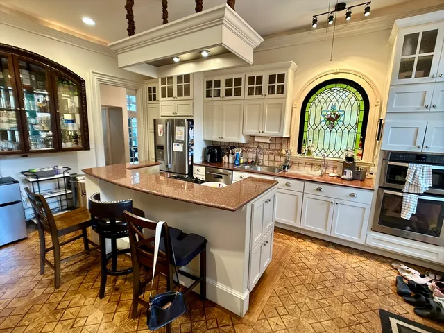a kitchen with stainless steel appliances granite countertop a stove a sink dishwasher and cabinets with wooden floor
