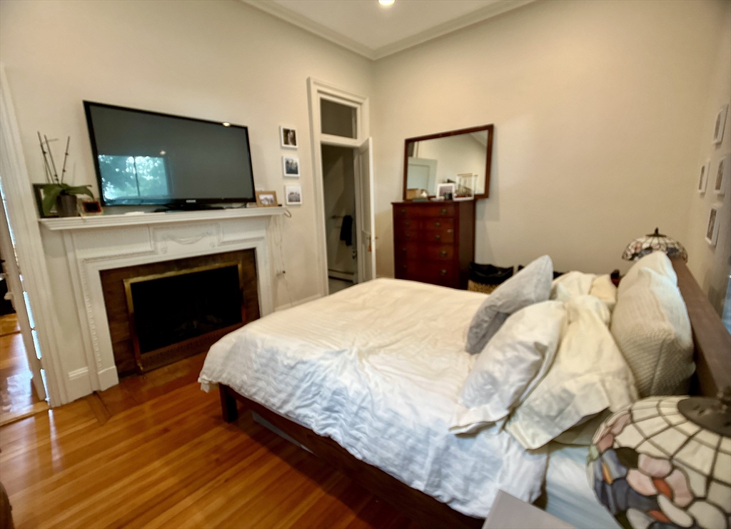 61 Pond Street, Unit 1 Boston, MA 02130 - Photo 11 of 18 a bedroom with a bed and a flat screen tv
