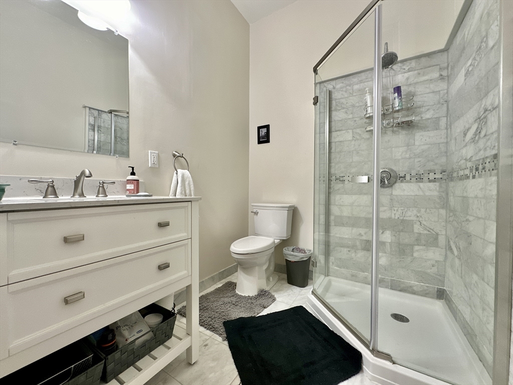 61 Pond Street, Unit 1 Boston, MA 02130 - Photo 12 of 18 a bathroom with a sink a toilet and shower