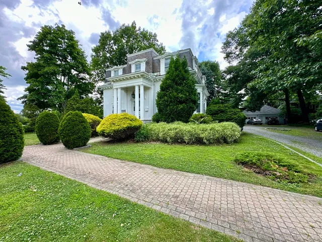 a front view of a house with a garden
