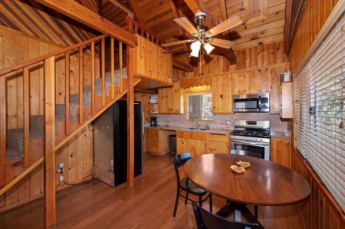 39187 Arapahoe Road Fawnskin, CA 92333 - Photo 12 of 33 a kitchen with stainless steel appliances granite countertop a stove a refrigerator a kitchen island a dining table and chairs with wooden floor