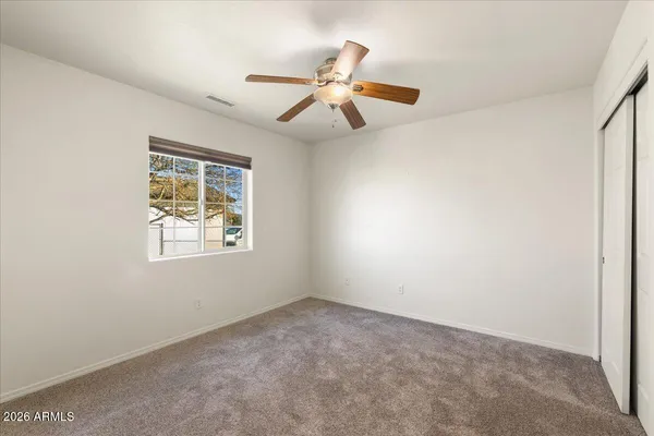 an empty room with a window and a fan