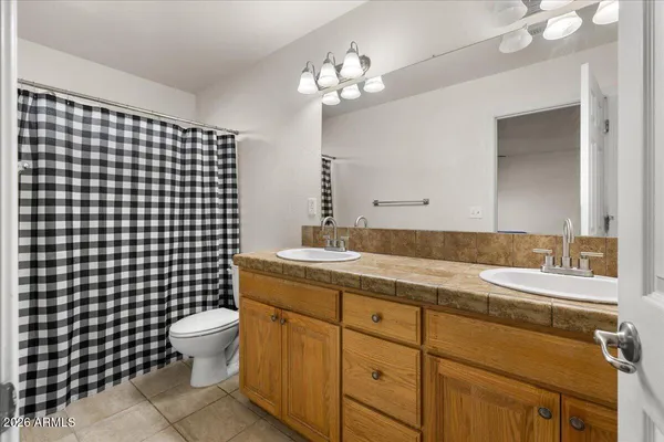a bathroom with a double vanity sink toilet and a mirror
