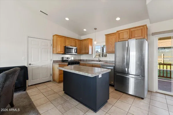 a kitchen with stainless steel appliances granite countertop a refrigerator a stove a sink and a microwave