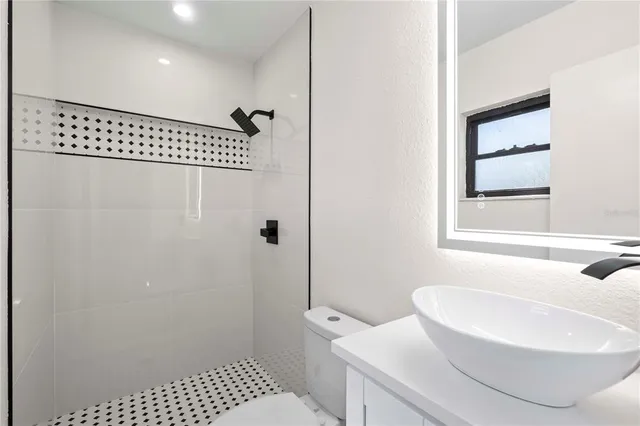 a backyard of a house with large trees and wooden fence