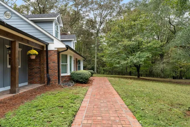 a living room with furniture a flat screen tv and a floor to ceiling window