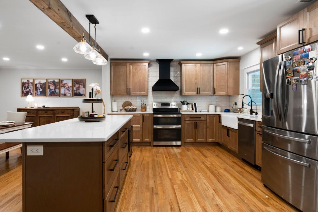 311 Herring Road Armuchee, GA 30105 - Photo 24 of 66 a kitchen with stainless steel appliances granite countertop a refrigerator a sink dishwasher a stove and white countertops with wooden floor