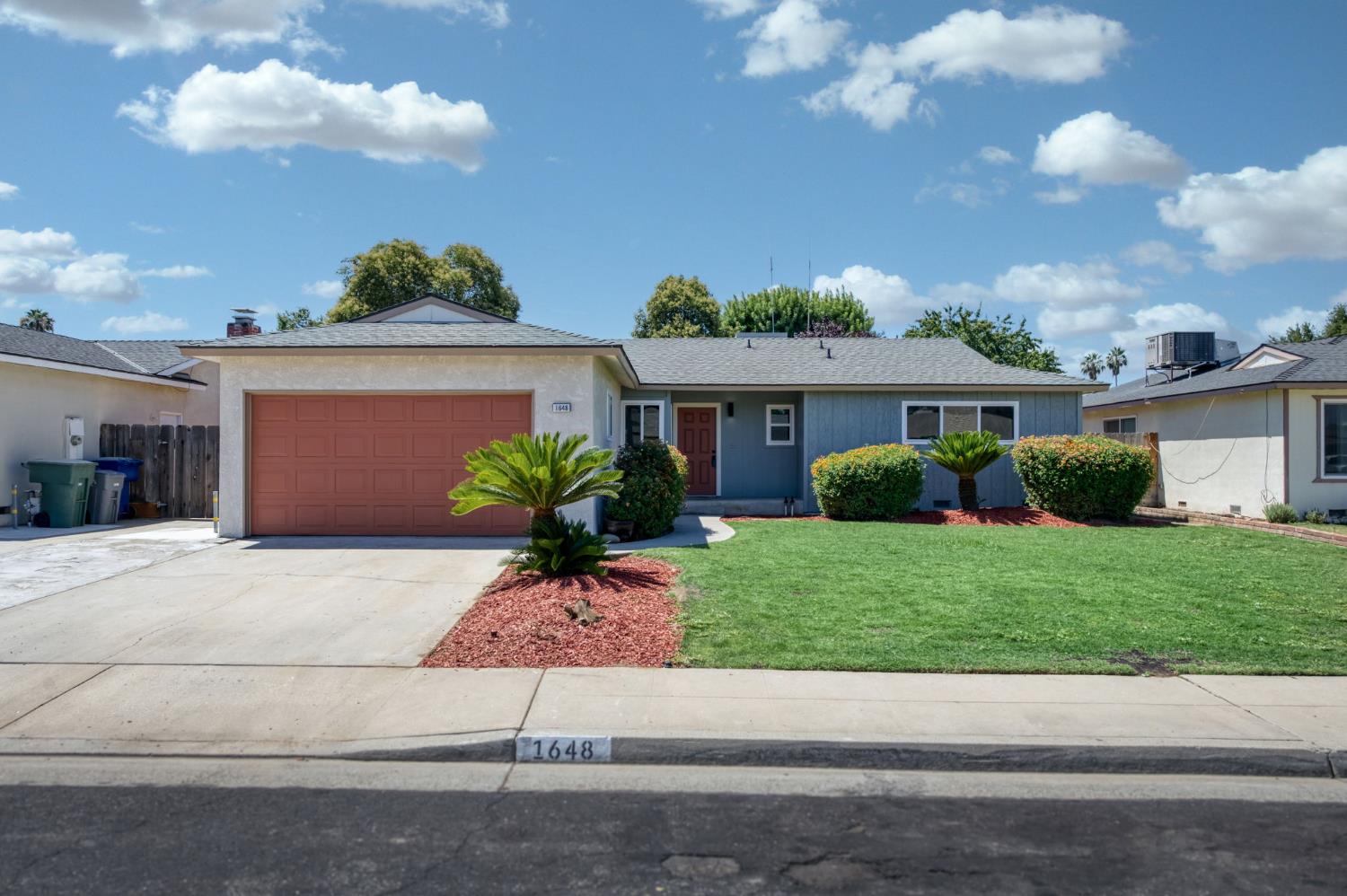 a front view of a house with a yard and a garage