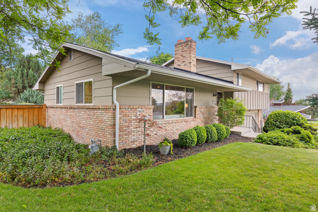 3320 Cherokee Lane Provo, UT 84604 - Photo 4 of 52 Split-level residence featuring brick and siding exterior, a prominent brick chimney, and a well-maintained lawn