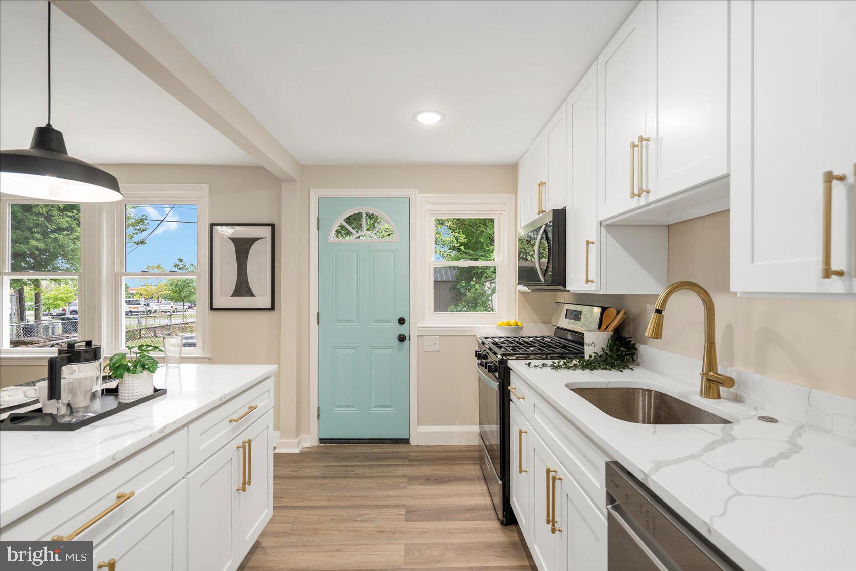 3531 Elmora Avenue Baltimore, MD 21213 - Photo 19 of 38 a kitchen with a sink a stove and cabinets