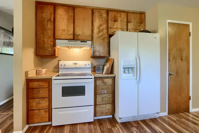 a view of an empty room with stairs and a window