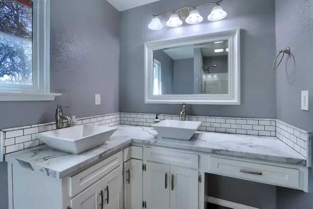 a bathroom with a granite countertop toilet a sink and shower