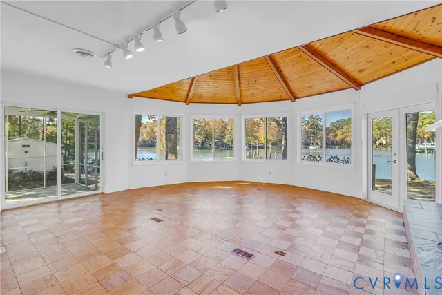 an empty room with windows and fireplace