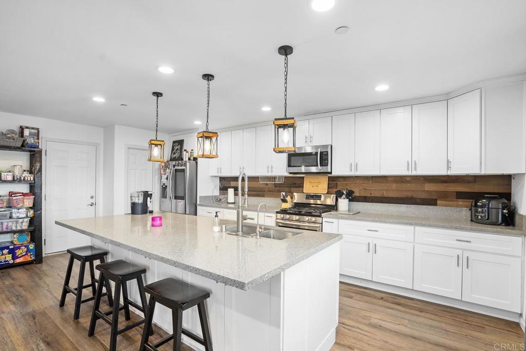 20591 Sycamore Springs Road Jamul, CA 91935 - Photo 14 of 53 a kitchen with kitchen island granite countertop a sink a center island stainless steel appliances and cabinets