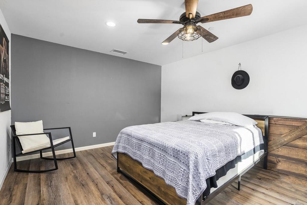 20591 Sycamore Springs Road Jamul, CA 91935 - Photo 17 of 53 a bedroom with a bed and a chandelier