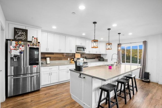 a kitchen with stainless steel appliances a stove a sink a refrigerator and cabinets