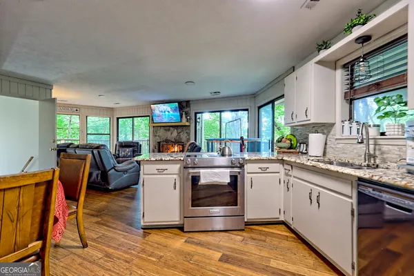 a kitchen with a stove a sink and a wooden cabinets