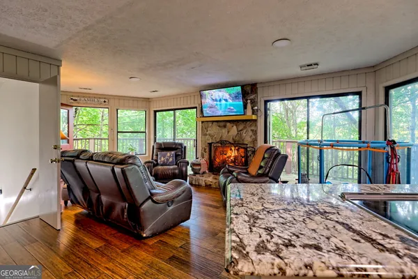a living room with furniture a fireplace and a floor to ceiling window