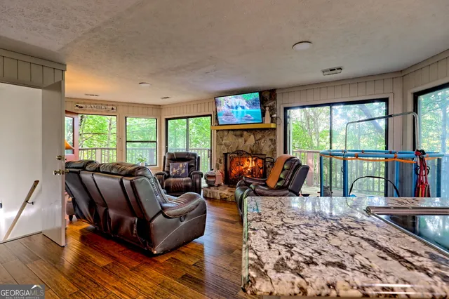 a living room with furniture a fireplace and a floor to ceiling window