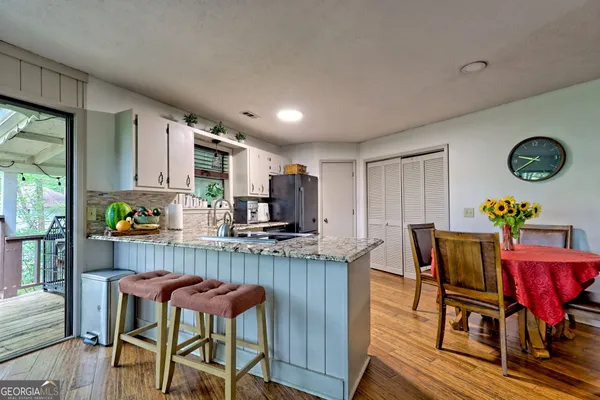 a kitchen with stainless steel appliances granite countertop sink dining table and chairs