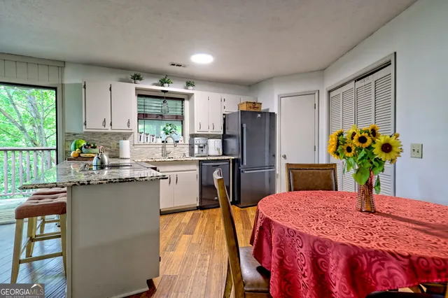 a kitchen that has a lot of cabinets in it and wooden floors