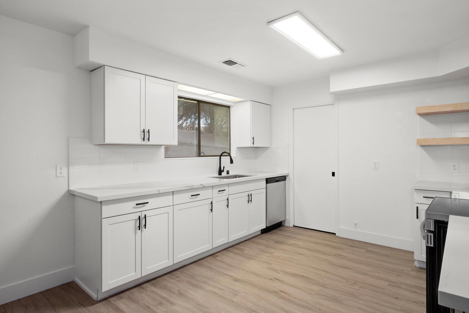 51202 Rusty Lane Oakhurst, CA 93644 - Photo 11 of 27 a kitchen with sink cabinets and wooden floor