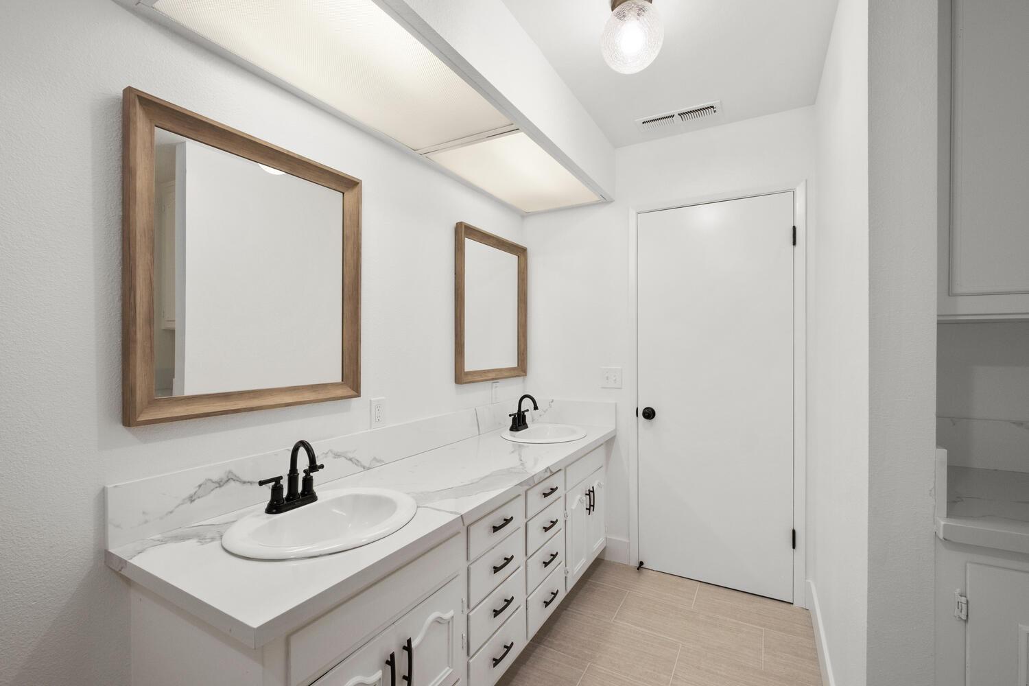 51202 Rusty Lane Oakhurst, CA 93644 - Photo 16 of 27 a bathroom with 2 sink and a mirror