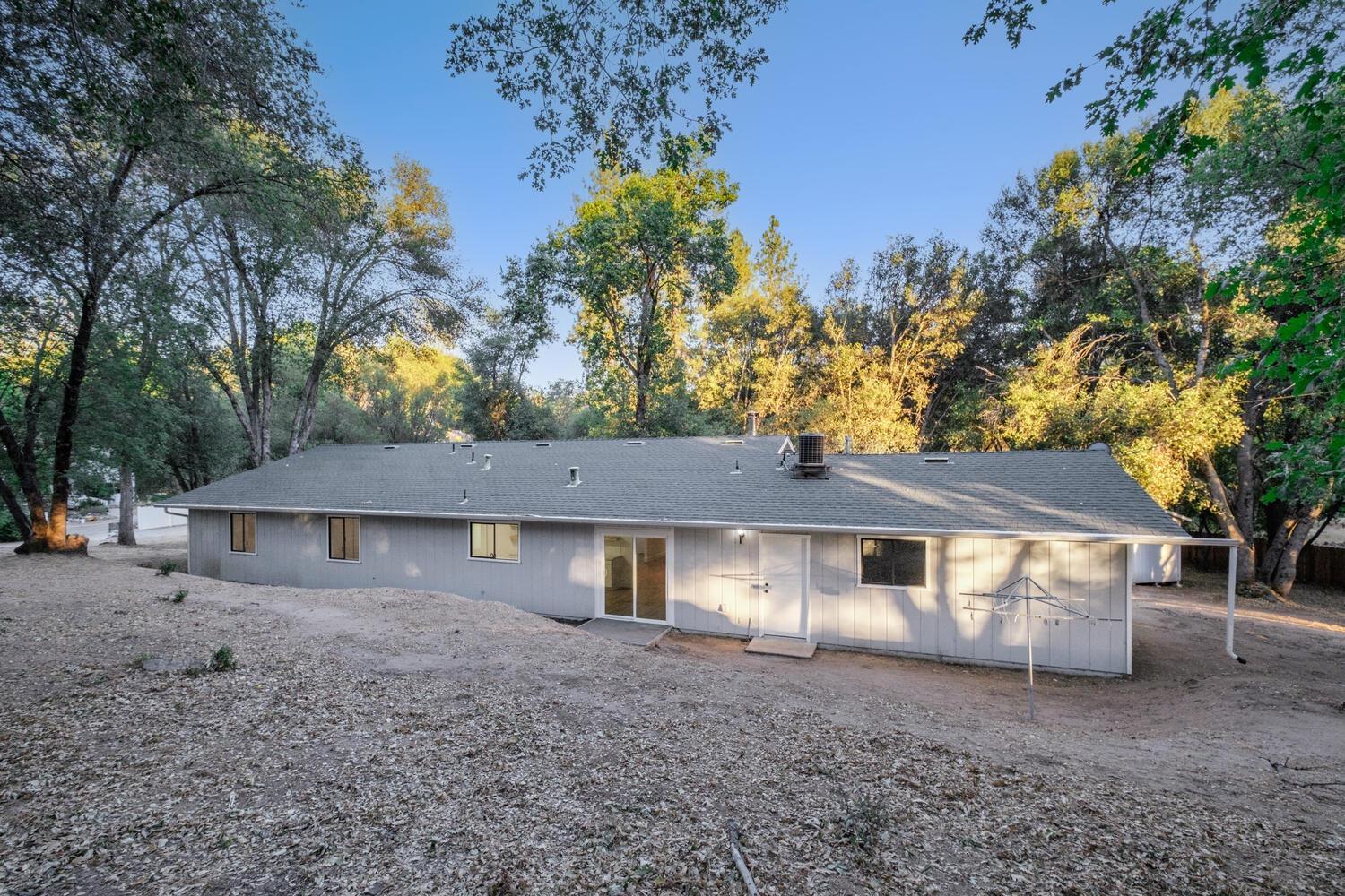 51202 Rusty Lane Oakhurst, CA 93644 - Photo 22 of 27 a front view of a house with a yard and garage