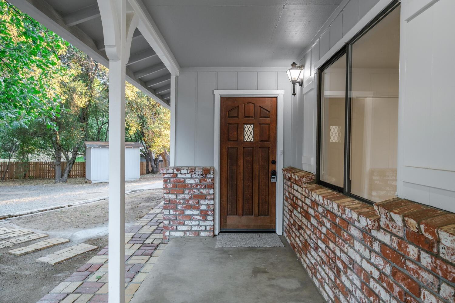 51202 Rusty Lane Oakhurst, CA 93644 - Photo 4 of 27 a view of a porch with a door and wooden floor