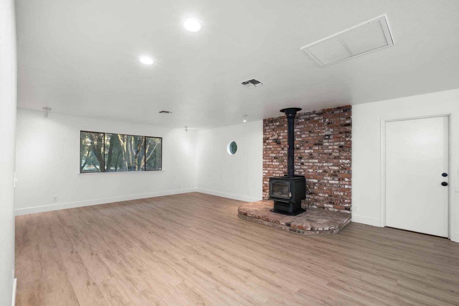 51202 Rusty Lane Oakhurst, CA 93644 - Photo 8 of 27 a view of an empty room with wooden floor and windows