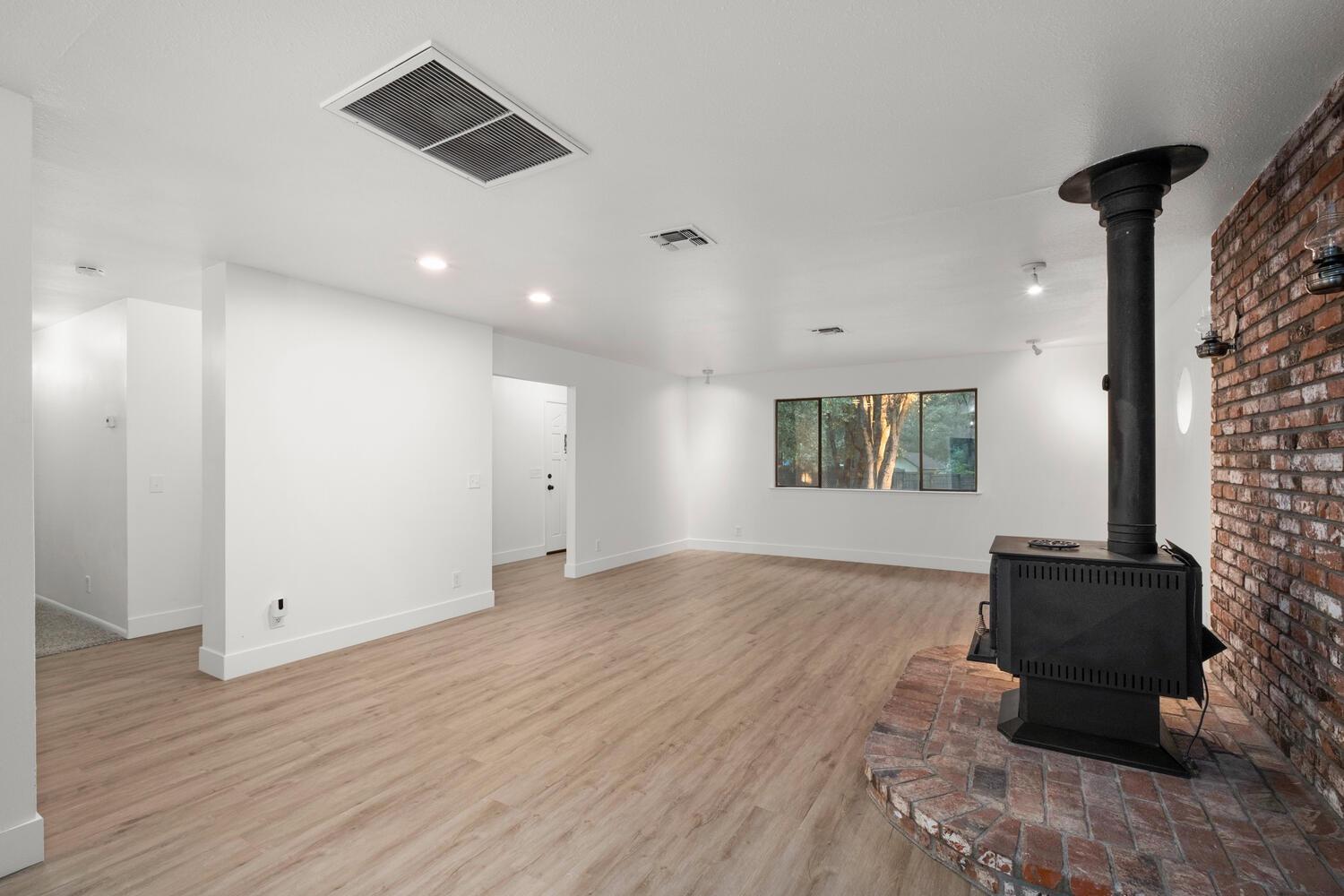51202 Rusty Lane Oakhurst, CA 93644 - Photo 9 of 27 an empty room with wooden floor and windows