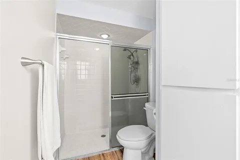 a bathroom with a granite countertop shower and a toilet