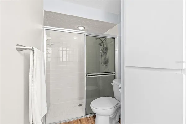 a bathroom with a granite countertop shower and a toilet