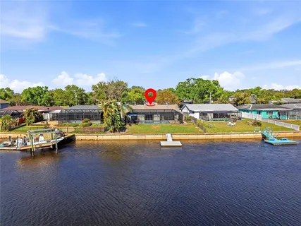 a view of swimming pool with seating area and trees in the background