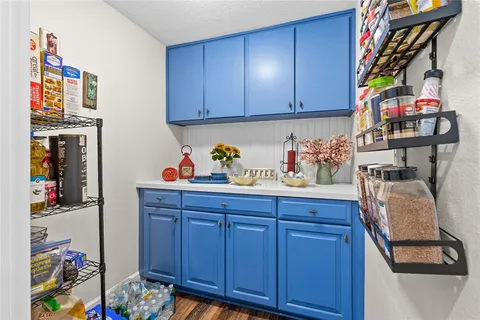 a utility room with lots of clutter and cabinets