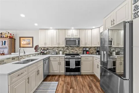 a kitchen with cabinets stainless steel appliances and sink