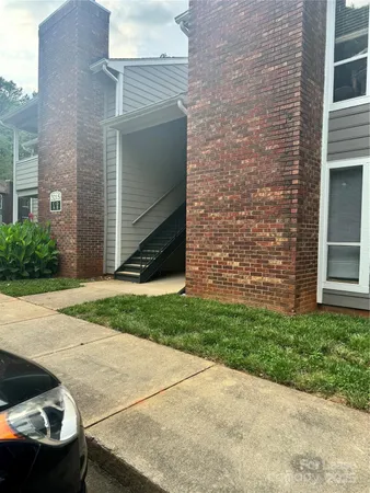 a view of backyard with brick wall and potted plants