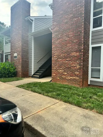a view of backyard with brick wall and potted plants