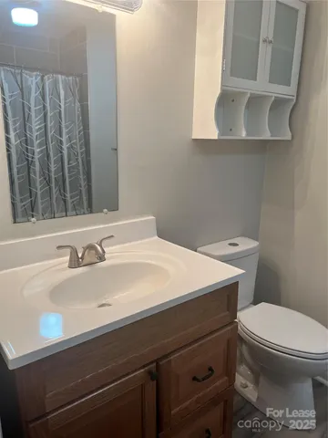 a bathroom with a sink a toilet and mirror