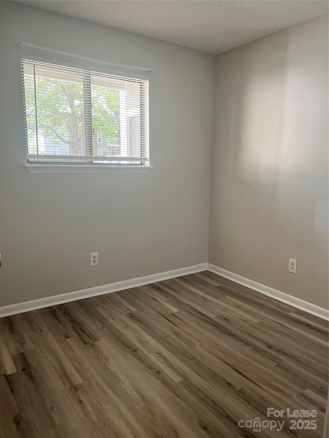 3215 Heathstead Place Charlotte, NC 28210 - Photo 8 of 10 an empty room with wooden floor and windows