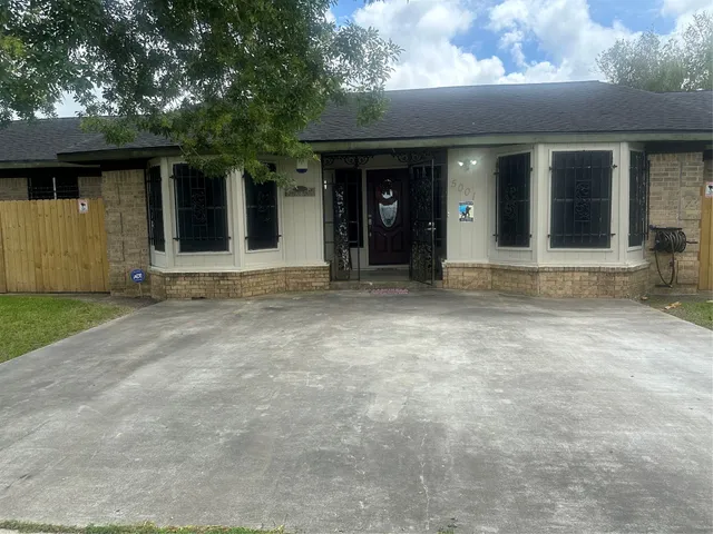 a view of yellow house with a large window and yard in front of it