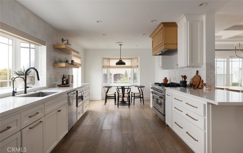 1120 Dolphin Terrace Corona del Mar, CA 92625 - Photo 18 of 48 a kitchen with wooden floors white cabinets and sink