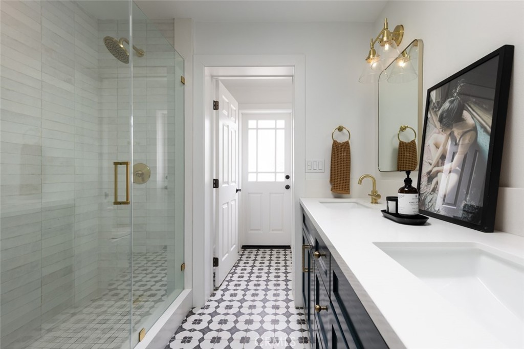 1120 Dolphin Terrace Corona del Mar, CA 92625 - Photo 27 of 48 a bathroom with a sink a double vanity mirror and shower