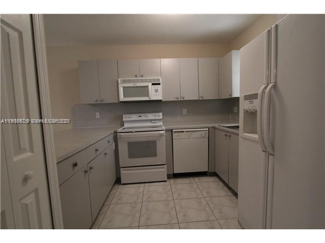 6761 Northwest 182nd Street, Unit 104 Hialeah, FL 33015 - Photo 2 of 12 a kitchen with cabinets stainless steel appliances and a sink