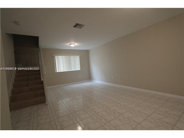 6761 Northwest 182nd Street, Unit 104 Hialeah, FL 33015 - Photo 5 of 12 a view of an empty room and window