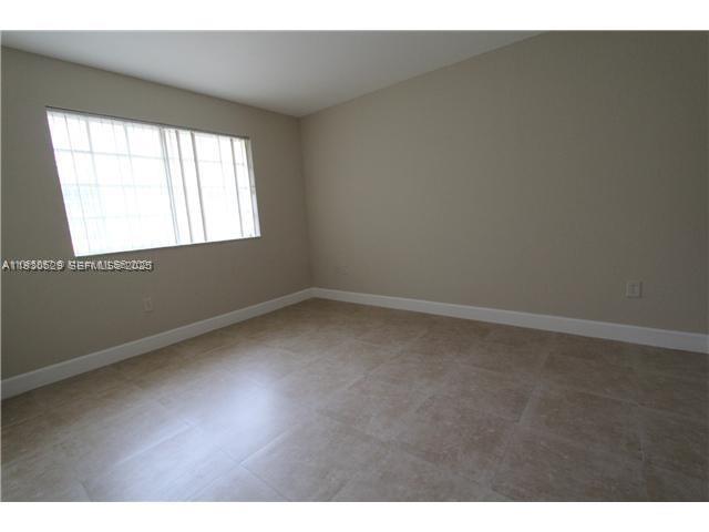6761 Northwest 182nd Street, Unit 104 Hialeah, FL 33015 - Photo 8 of 12 a view of an empty room with a window
